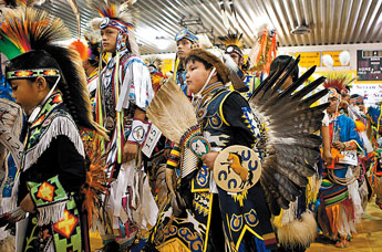 Dancers and performers of different Native American nations march in the Chinle Community Center before the beginning of the contest powwow honoring former Navajo president Joe Shirley Jr., on Friday afternoon. © 2011 Gallup Independent / Diego James Robles